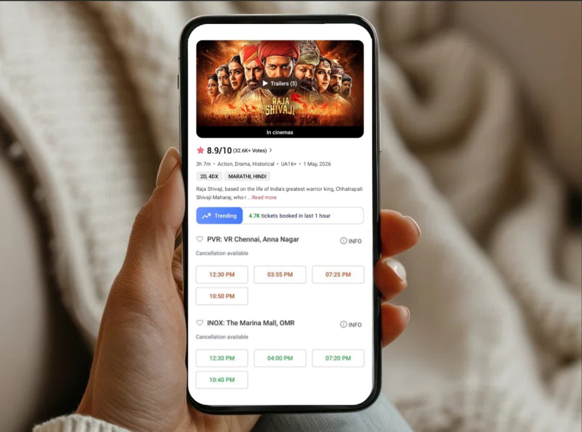 The film's BookMyShow listing open on a phone, rating, showtimes and cinemas visible